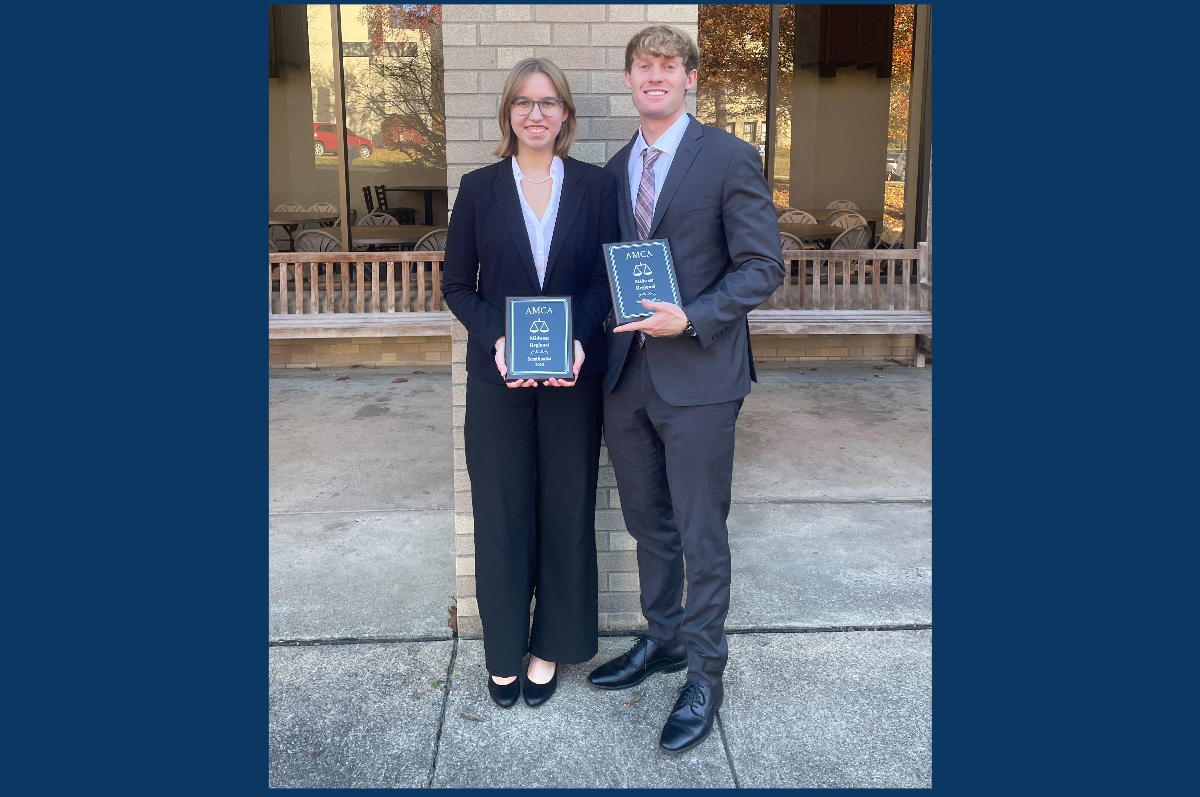 two students holding awards